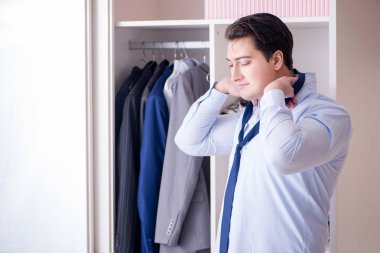 Genç işadamı iş için giyiniyor.