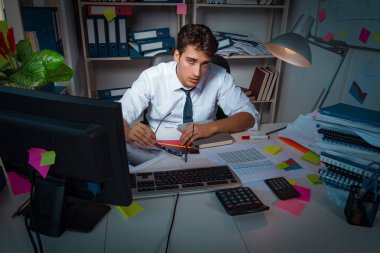 İş adamı ofiste geç saatlere kadar çalışıyor.