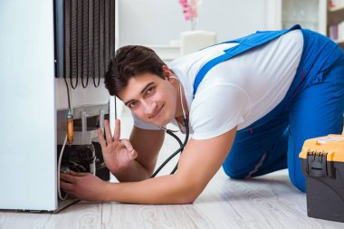 Tamirci müteahhit DIY konseptinde buzdolabını tamir ediyor.