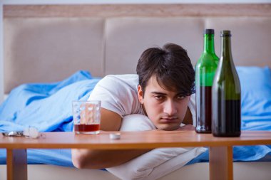 Yatakta içen alkolik adam depresyona giriyor.
