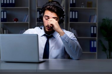 Çağrı merkezindeki genç adam geç saatlere kadar çalışıyor.