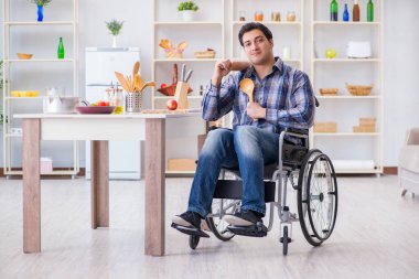 Engelli genç koca mutfakta çalışıyor.