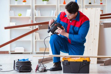 Genç marangoz ahşap kalaslarla çalışıyor.