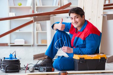 Genç marangoz ahşap kalaslarla çalışmaya ara veriyor.