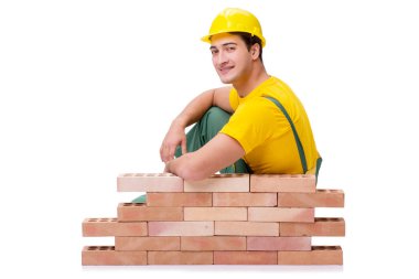 Yakışıklı inşaat işçisi tuğla duvar inşa ediyor.