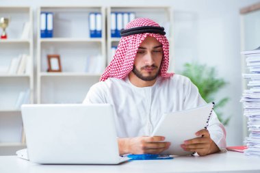 Ofiste çalışan Arap işadamı bir Pi ile evrak işi yapıyor.