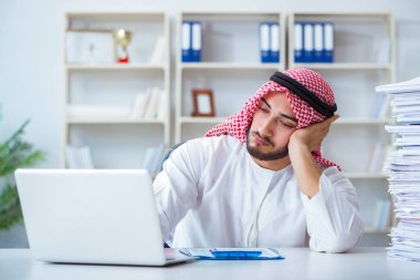 Ofiste çalışan Arap işadamı bir Pi ile evrak işi yapıyor.