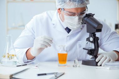 Laboratuvarda parfüm karıştıran bir kimyager.