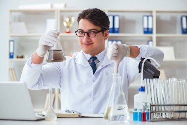 Genç araştırmacı bilim adamı bir su testi kirliliği araştırması yapıyor.
