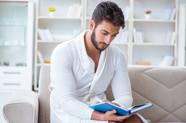 Öğrenci işadamı genç adam bir kitap okuyor.