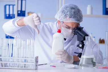 Laboratuvardaki adam yeni temizlik çözeltisi deterjanı test ediyor.
