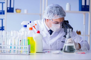 Laboratuvardaki adam yeni temizlik çözeltisi deterjanı test ediyor.