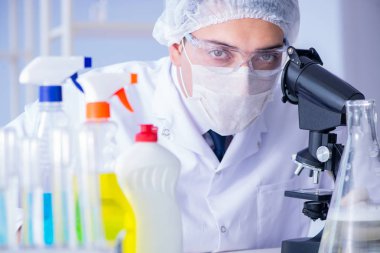 Laboratuvardaki adam yeni temizlik çözeltisi deterjanı test ediyor.
