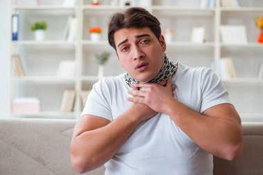Genç adam boğaz ağrısı çekiyor.