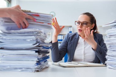 Evrak işleriyle uğraşan yorgun bir iş kadını.