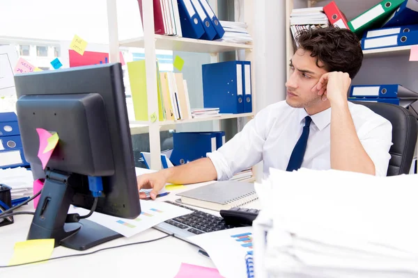 Businessman working in the office with piles of books and papers — Stock Photo, Image