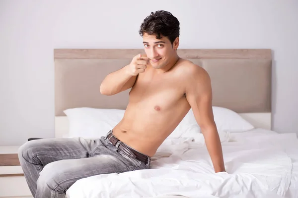 Молодой красивый парень без рубашки, показывающий обнажённое тело сексуально на кровати в час — стоковое фото