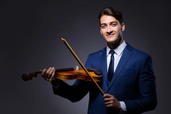 Young man playing violin in dark room — Stock Photo, Image