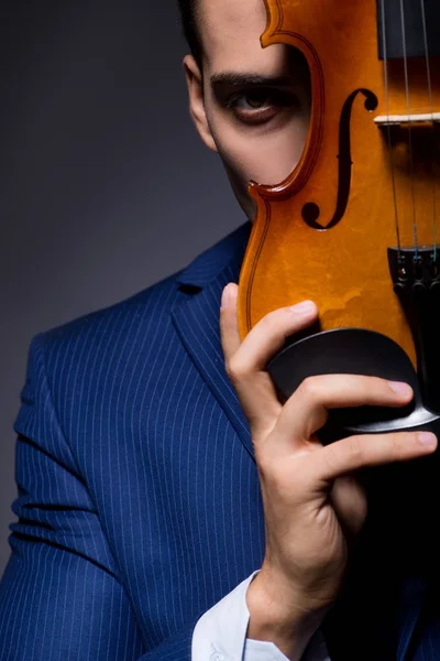 Jeune homme jouant du violon dans la chambre noire — Photo