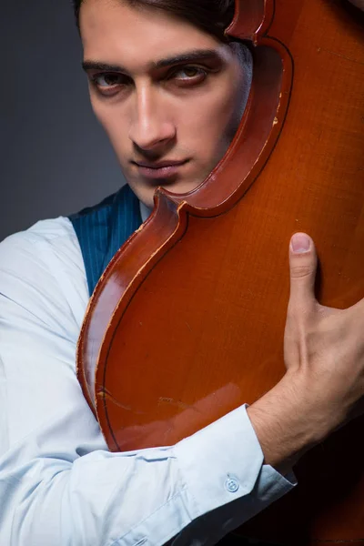 Joven tocando el violonchelo en habitación oscura —  Fotos de Stock