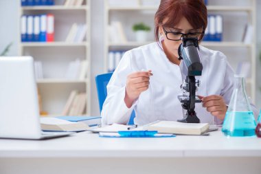 Bir laboratuarda deney yapan kadın bir bilim adamı.