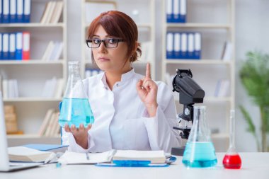 Bir laboratuarda deney yapan kadın bir bilim adamı.