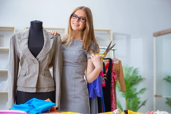 Mujer joven sastre trabajando en taller sobre vestido nuevo — Foto de Stock