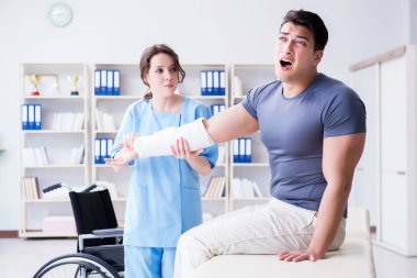 Hastanede yaralanma kontrolü sırasında doktor ve hasta.