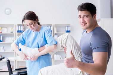 Hastanede yaralanma kontrolü sırasında doktor ve hasta.