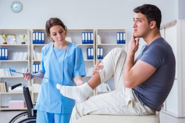 Hastanede yaralanma kontrolü sırasında doktor ve hasta.
