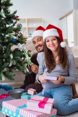 Genç aile Noel 'i kutlayan bir bebek bekliyor.