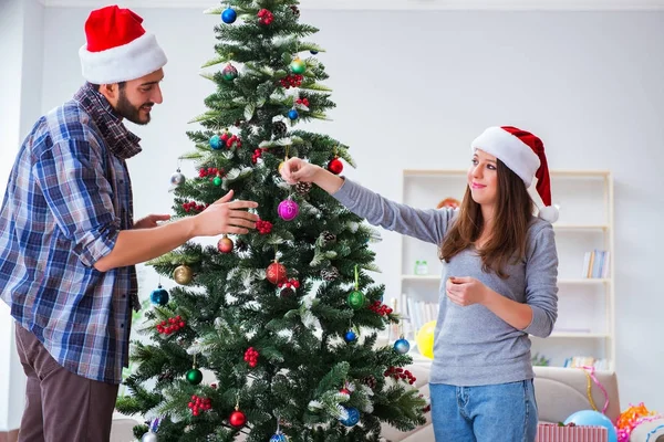 Genç aile Noel ağacını mutlu bir vesileyle süslüyor. — Stok fotoğraf