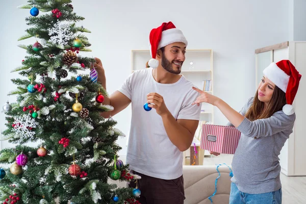 クリスマスを祝う子供の赤ちゃんを期待している若い家族 — ストック写真