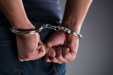 Man with his hands handcuffed in criminal concept clipart