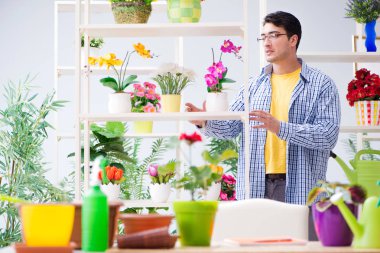 Bahçıvan çiçekçide çalışıyor. Çiçekçide çalışıyor.