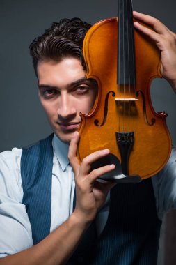 Genç müzisyen evde keman çalıyor.