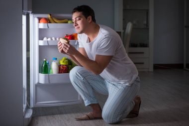 Buzdolabındaki adam gece yemek yiyor.