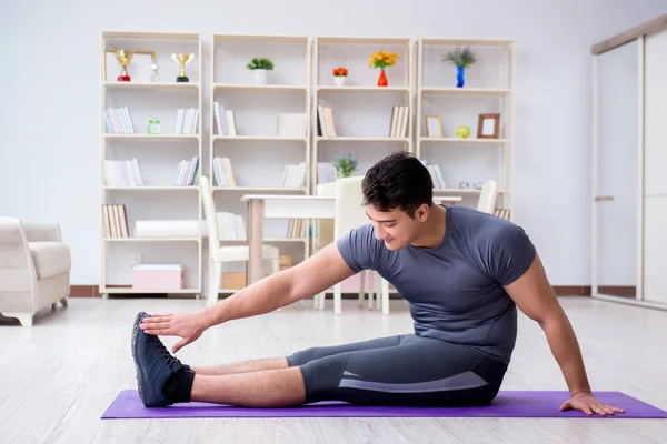 Giovane uomo che esercita a casa in sport e stile di vita sano con — Foto Stock