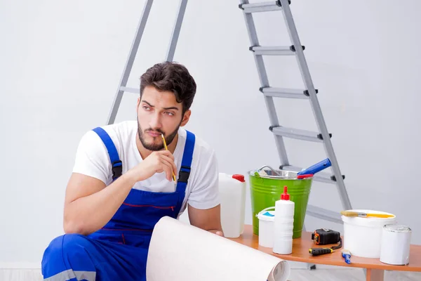 Opravář dělá renovaci opravy v domě s papírovou wallpa — Stock fotografie