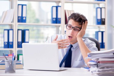 Yorgun iş adamı ofiste oturuyor.