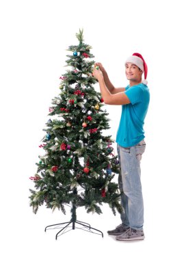 Genç adam beyaz üzerine izole edilmiş noel ağacını süslüyor.