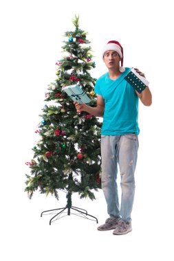 Genç adam beyaz üzerine izole edilmiş noel ağacını süslüyor.