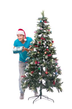 Genç adam beyaz üzerine izole edilmiş noel ağacını süslüyor.