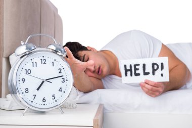 Yatakta uykusuzluk çeken bir adam.