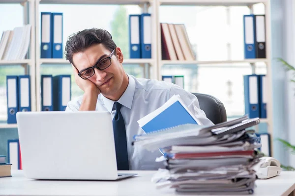 Бизнесмен с избыточной рабочей бумажной работой работает в офисе — стоковое фото