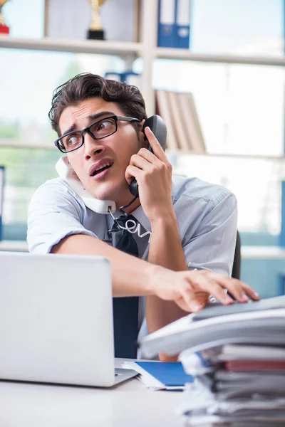 Joven hombre de negocios bajo presión en la oficina para entregar tareas —  Fotos de Stock