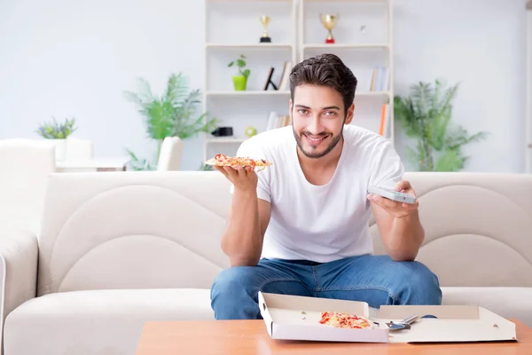 Pizza yiyen adam evde yemek yiyor, dinleniyor. — Stok fotoğraf