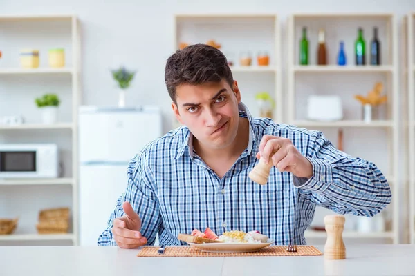 Νεαρός σύζυγος τρώει άγευστο φαγητό στο σπίτι για μεσημεριανό — Φωτογραφία Αρχείου