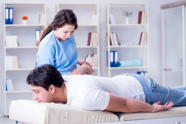 Medico chiropratico femminile che massaggia paziente maschile — Foto Stock