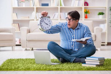 Genç yakışıklı adam evde yerde oturuyor.